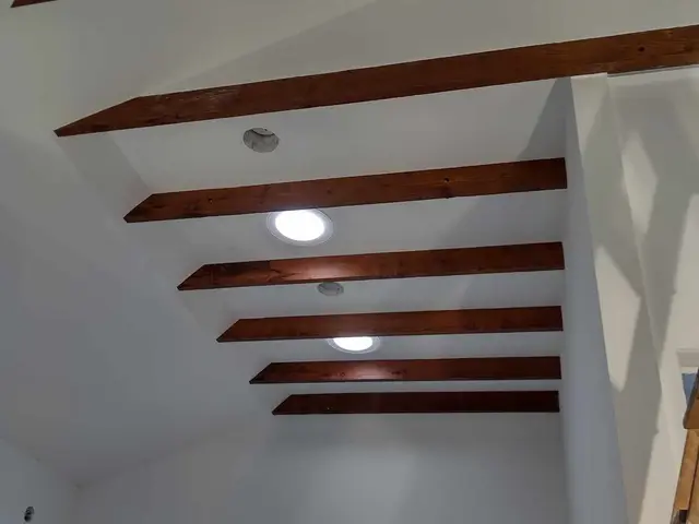 Vaulted ceiling with stained Douglas fir exposed beams and recessed lighting near Sandy, OR — Devine Home Remodeling & Construction