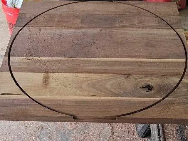 Solid walnut slab being templated for a round tabletop in the Estacada, OR shop — Devine Home Remodeling & Construction