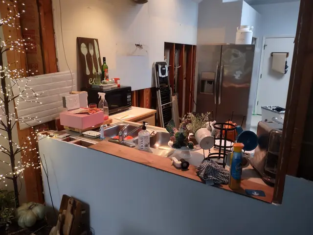 Original dated kitchen with worn countertops and exposed framing before remodel near Estacada, OR — Devine Home Remodeling & Construction