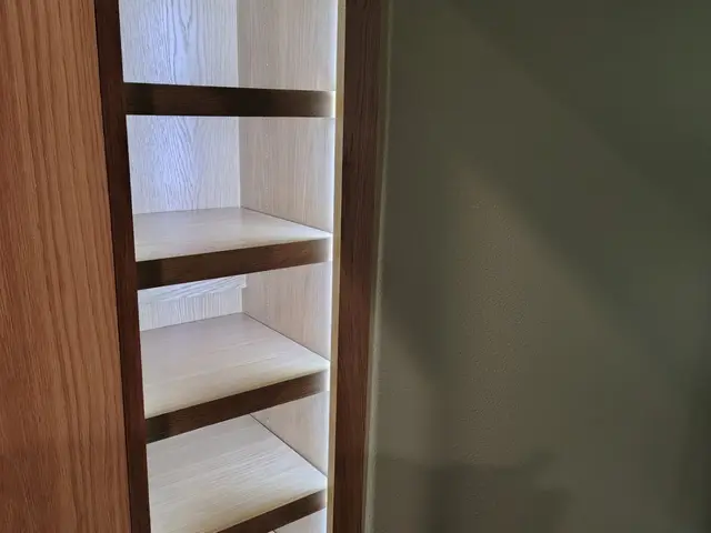 Illuminated custom closet shelving detail with wood trim near Estacada, OR — Devine Home Remodeling & Construction
