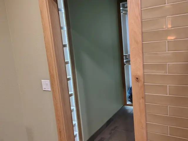 Stained wood cased opening connecting the shower room to custom closet near Estacada, OR — Devine Home Remodeling & Construction