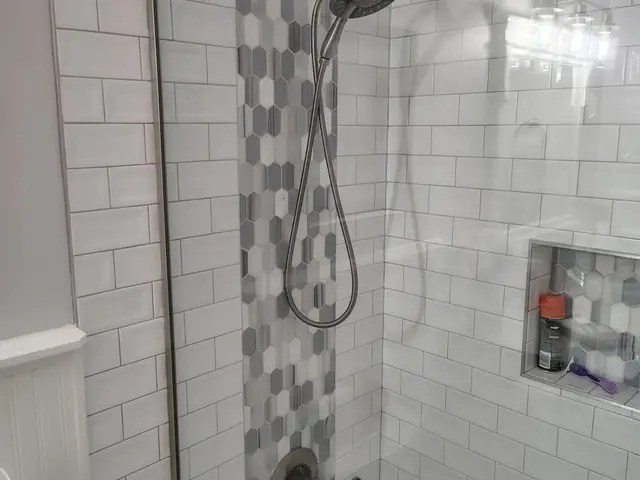 Tub-shower surround with hex mosaic accent strip and brushed nickel fixtures near Estacada, OR — Devine Home Remodeling & Construction