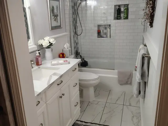 Bright guest bathroom remodel with white vanity, tub-shower combo, and marble-look flooring near Estacada, OR — Devine Home Remodeling & Construction